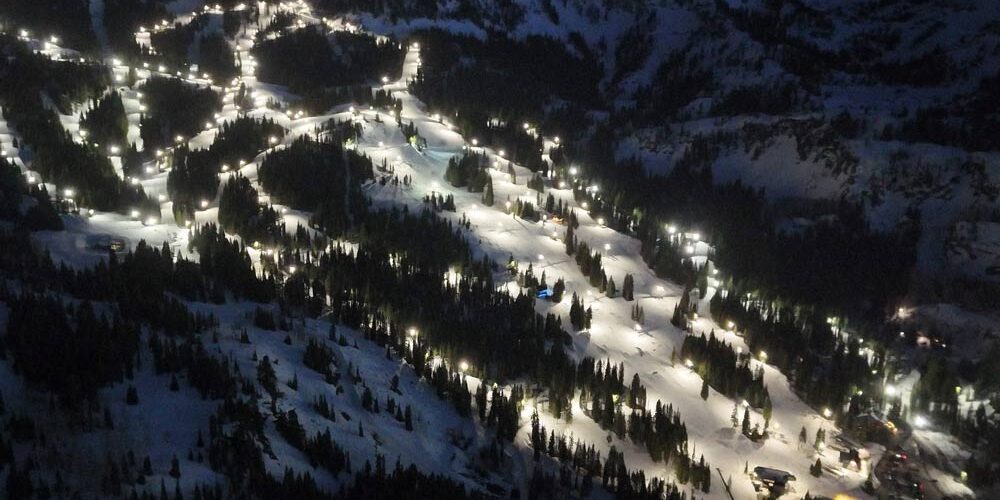 Brighton Ski Resort An aerial photo of an illuminated ski slope at night at Brighton Ski Resort