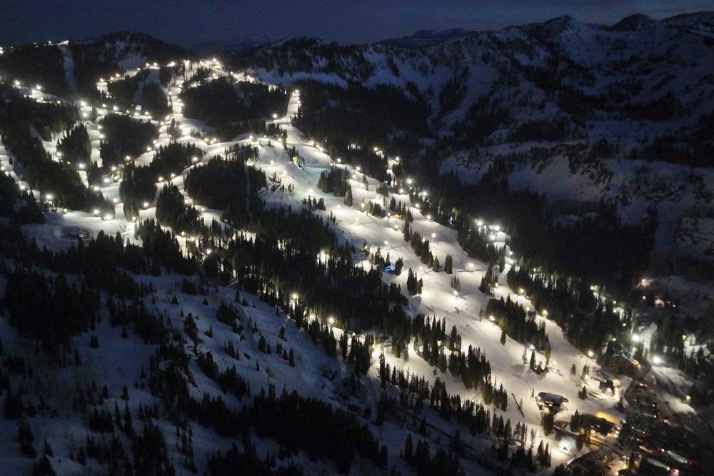 An aerial photo of an illuminated ski slope at night at Brighton Ski Resort