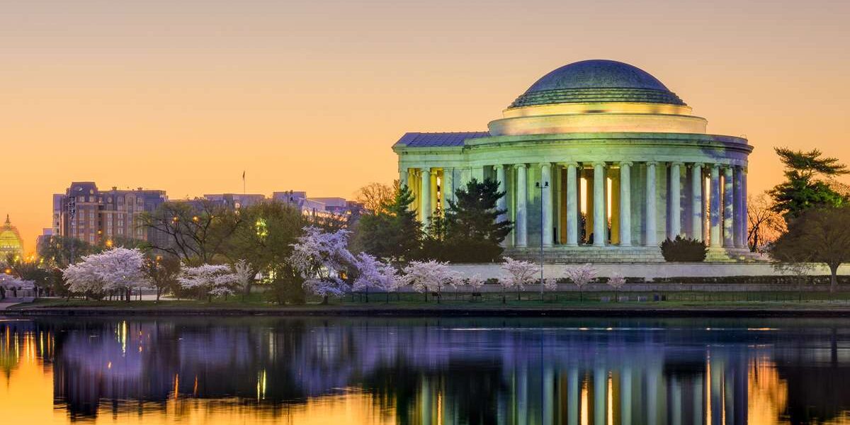 A photo of the Jefferson Memorial at sunset with the Mandarin Oriental Hotel in the background