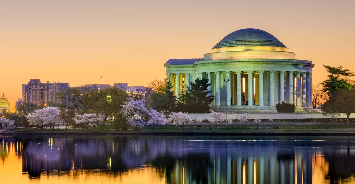 A photo of the Jefferson Memorial at sunset with the Mandarin Oriental Hotel in the background