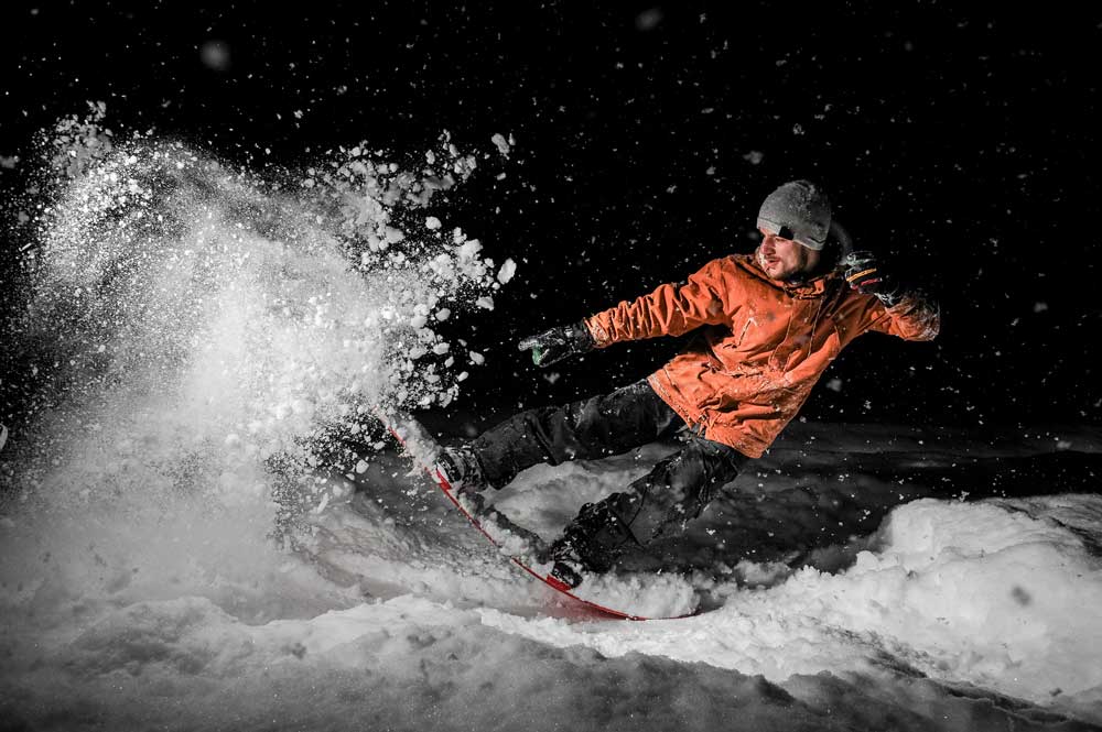 Brighton Ski Resort A snowboarder at night illuminated by exterior LED lighting