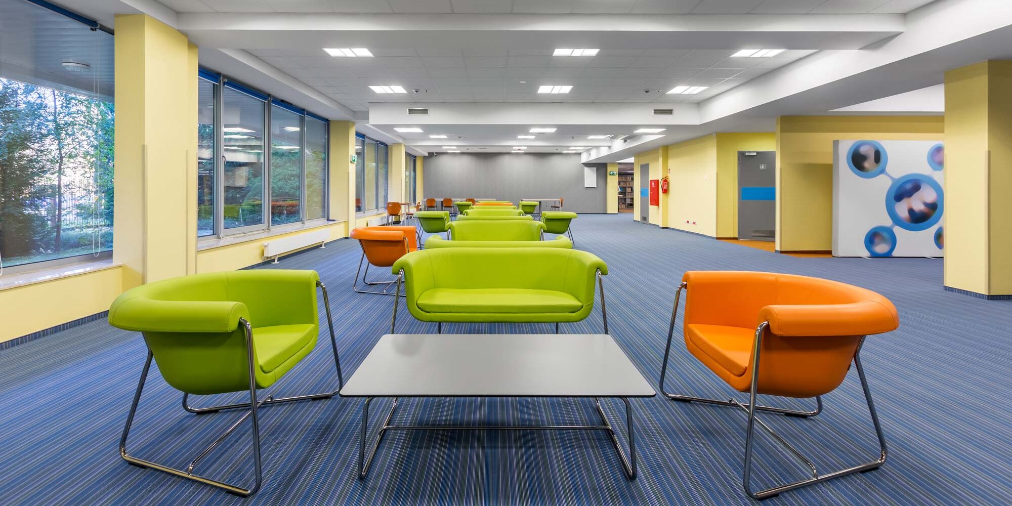 Basket troffers illuminate a colorful seating space in a commercial office