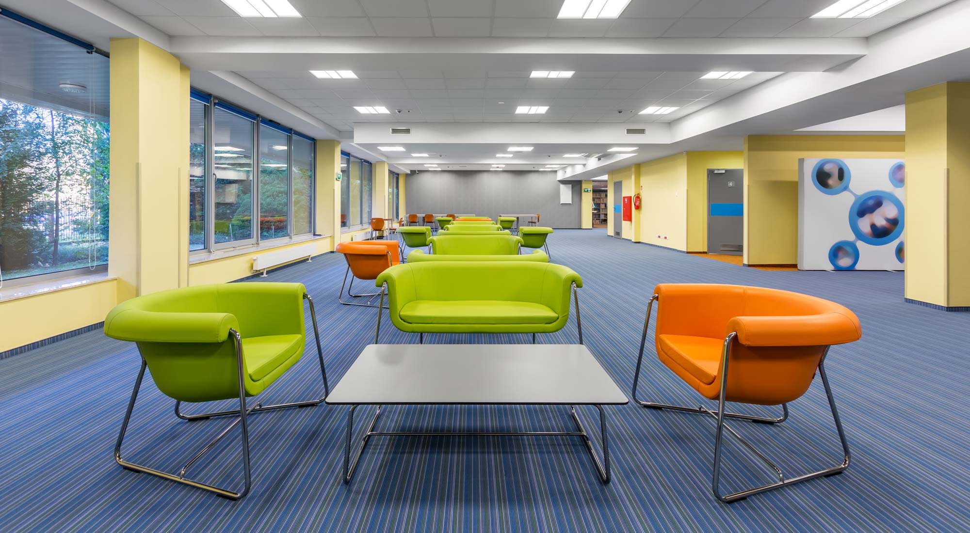 Basket troffers illuminate a colorful seating space in a commercial office