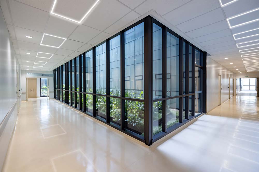 Commercial Lighting Thin, recessed rectangular linear lights in an office hallway surrounding an interior courtyard