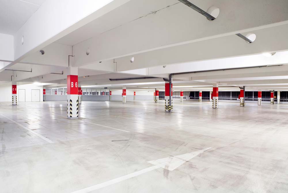 Commercial Lighting Canopy light fixtures illuminate an empty modern parking garage