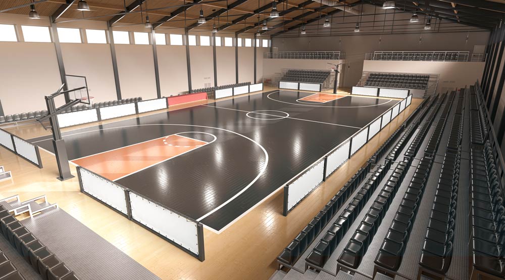 Lighting for Educational Facilities Shaded high bay lights are suspended from the ceiling of a high school basketball court