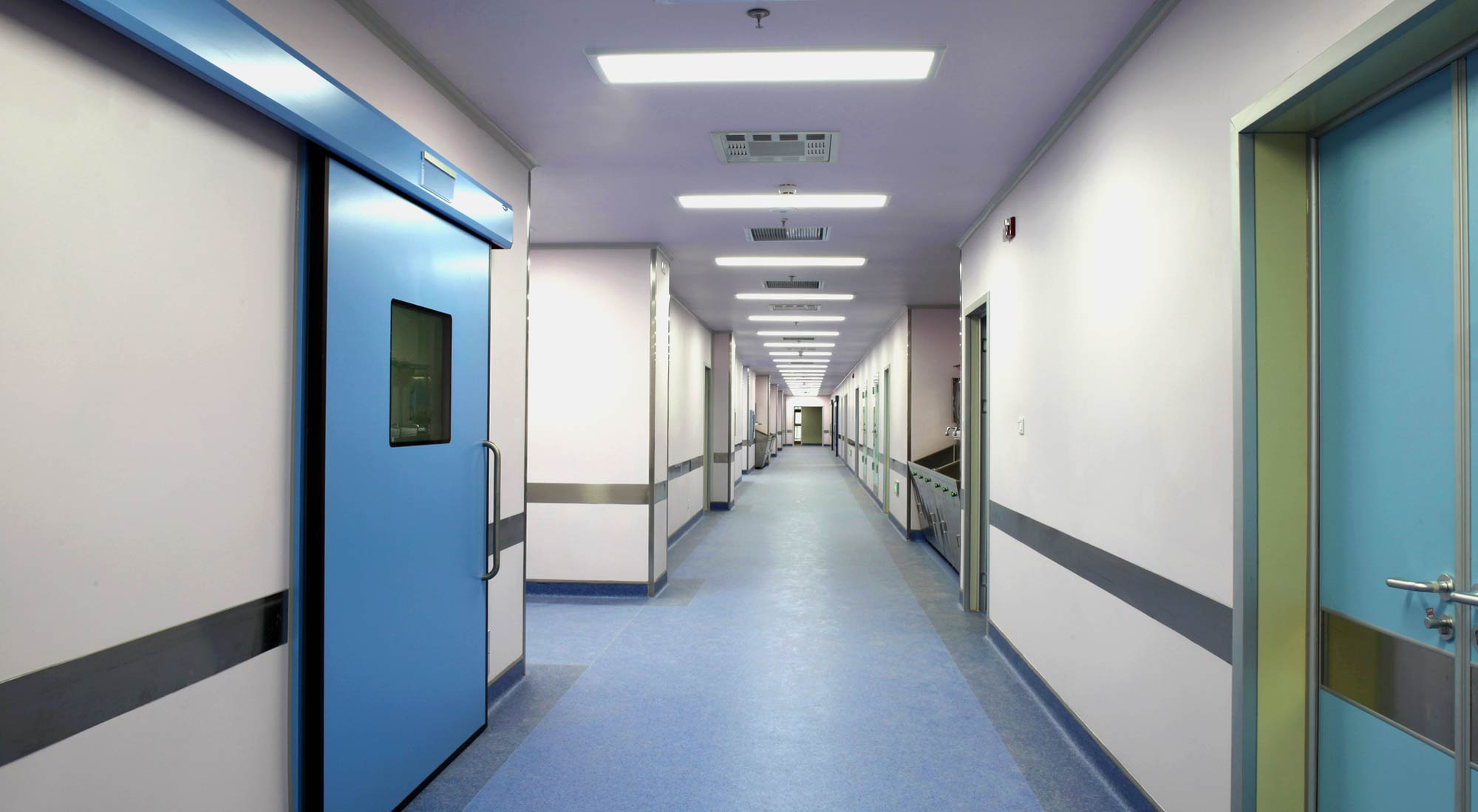Recessed LED troffers illuminate a hospital corridor
