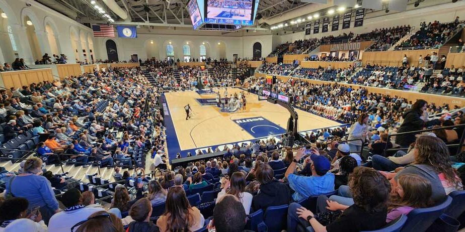 LED high bay lighting illuminates a university's packed indoor basketball court during a game