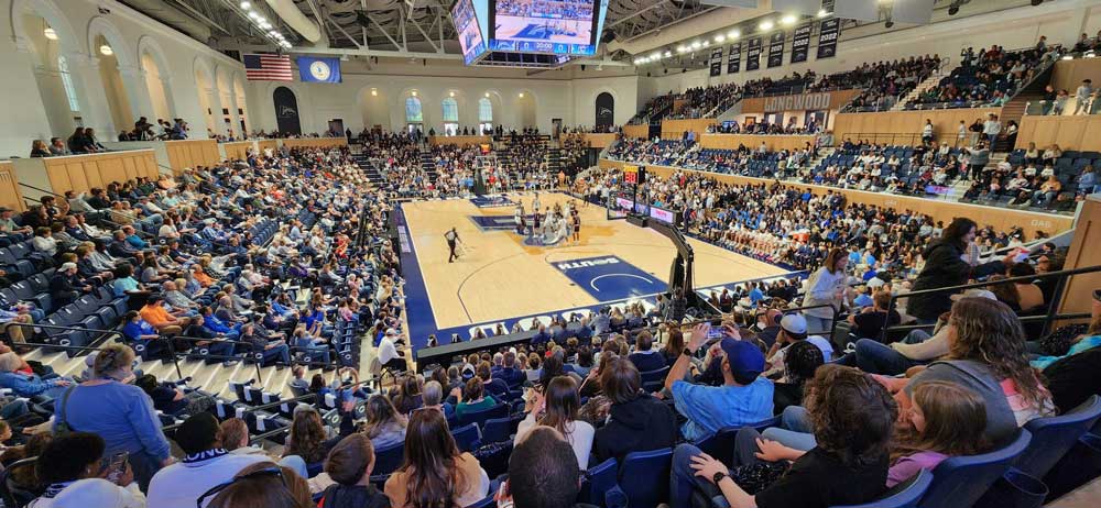 LED high bay lighting illuminates a university's packed indoor basketball court during a game