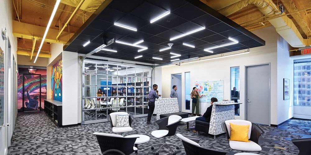PPG Place Geometric grid lighting creates visual interest on a black drop ceiling in an office space
