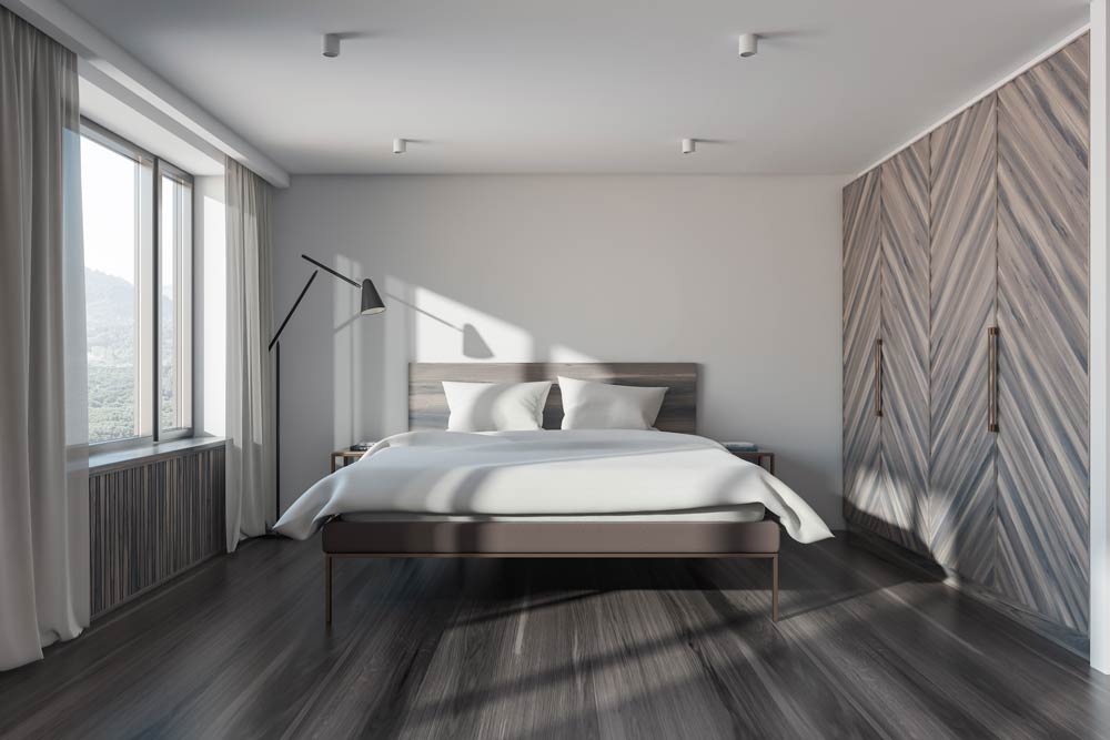 Residential Lighting Cylindrical downlights and a black shaded floor lamp in a sleek, minimalistic bedroom.