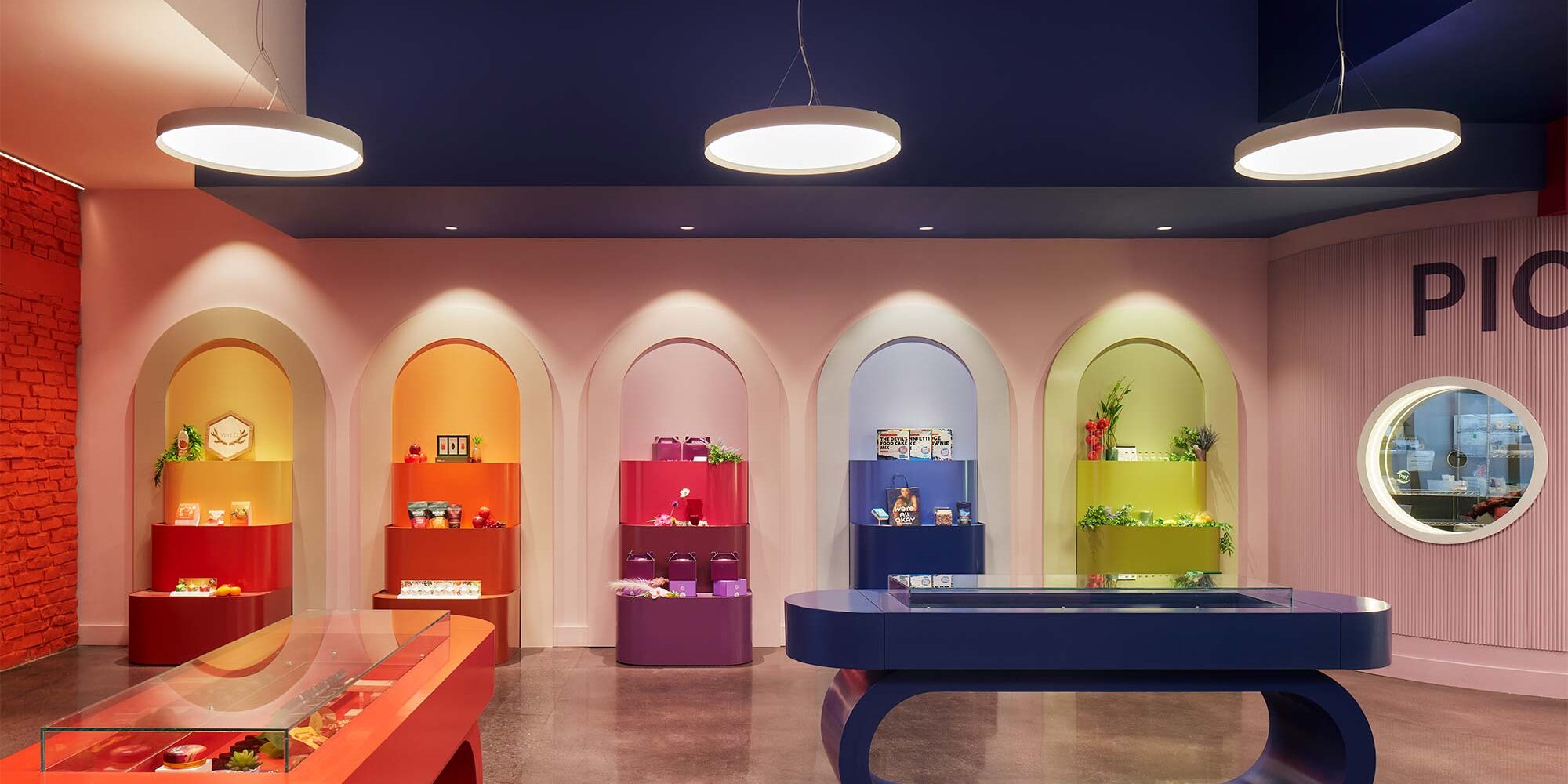 Modern circular pendant lights and recessed downlights highlight products in a colorful store