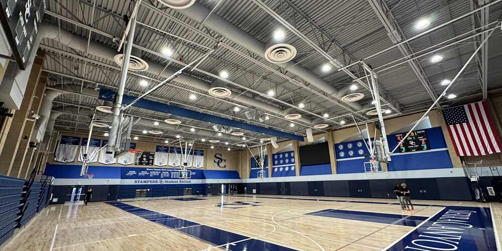 LED high bay lighting illuminates a high school's indoor basketball court