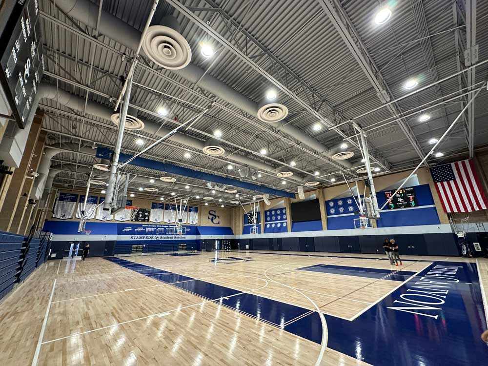 LED high bay lighting illuminates a high school's indoor basketball court